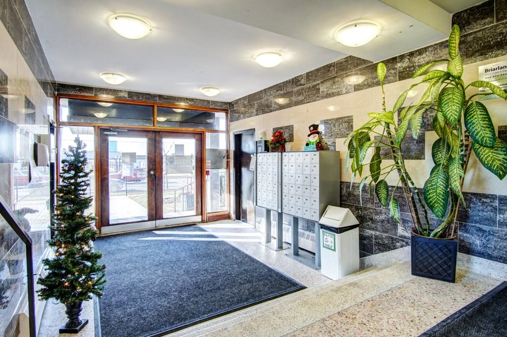 the lobby of a building with a christmas tree and a glass door