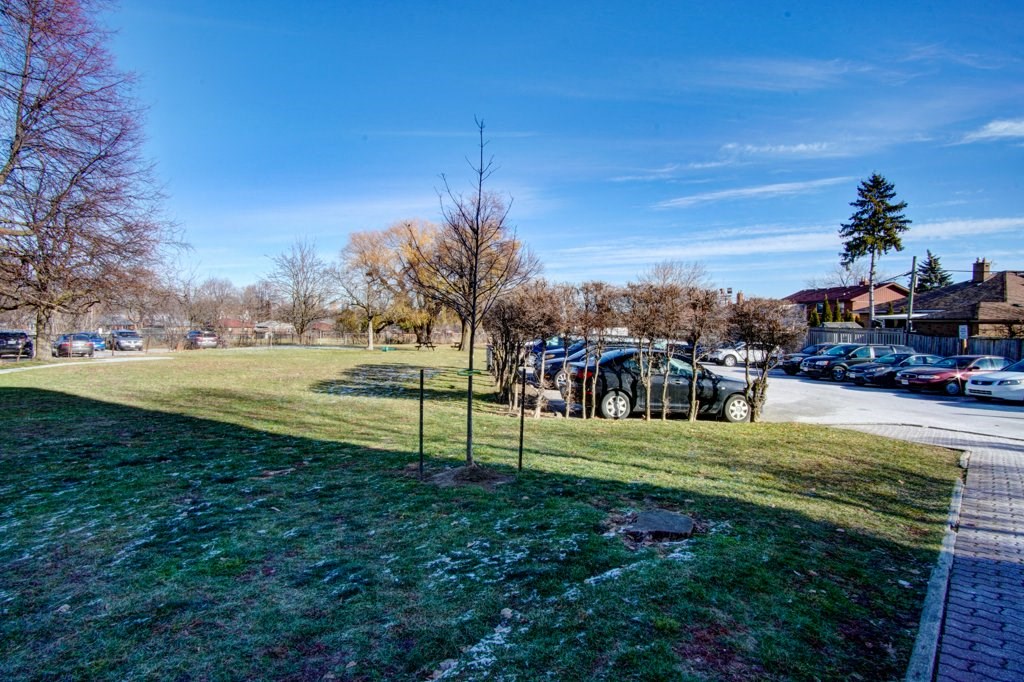 a car parked in the grass next to a parking lot
