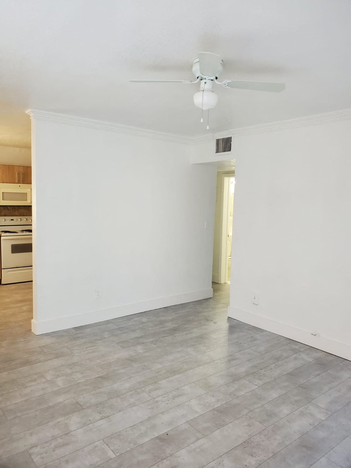 A room with a ceiling fan and a light hanging from it.