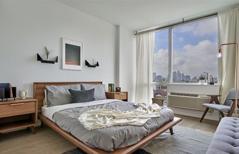 A bedroom with a large bed and a view of the city.