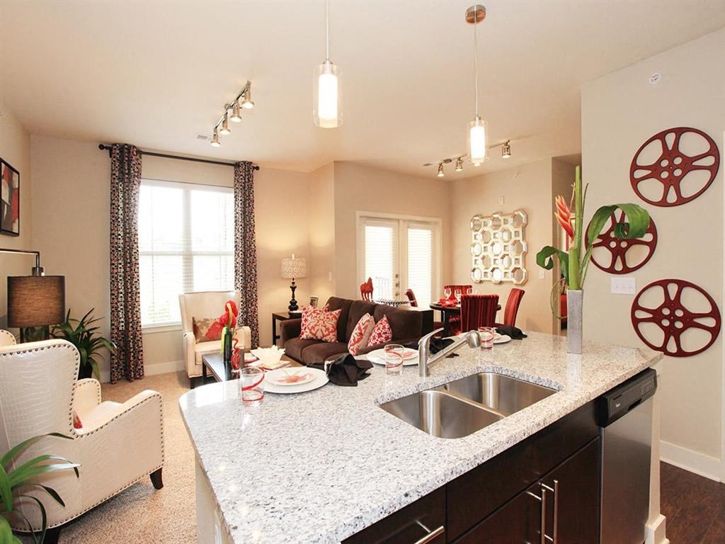 a kitchen and living room with a granite counter top
