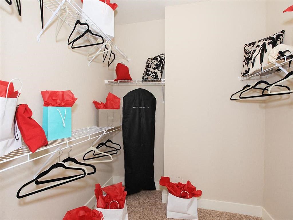 a walk in closet filled with shoes and bags