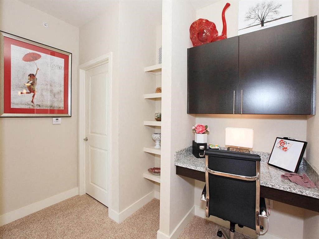a small desk in a room with a chair and a television