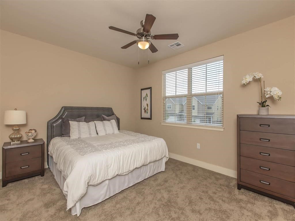 a bedroom with a bed and a ceiling fan