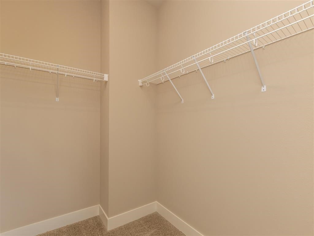 a walk in closet with a hanging rack on the wall