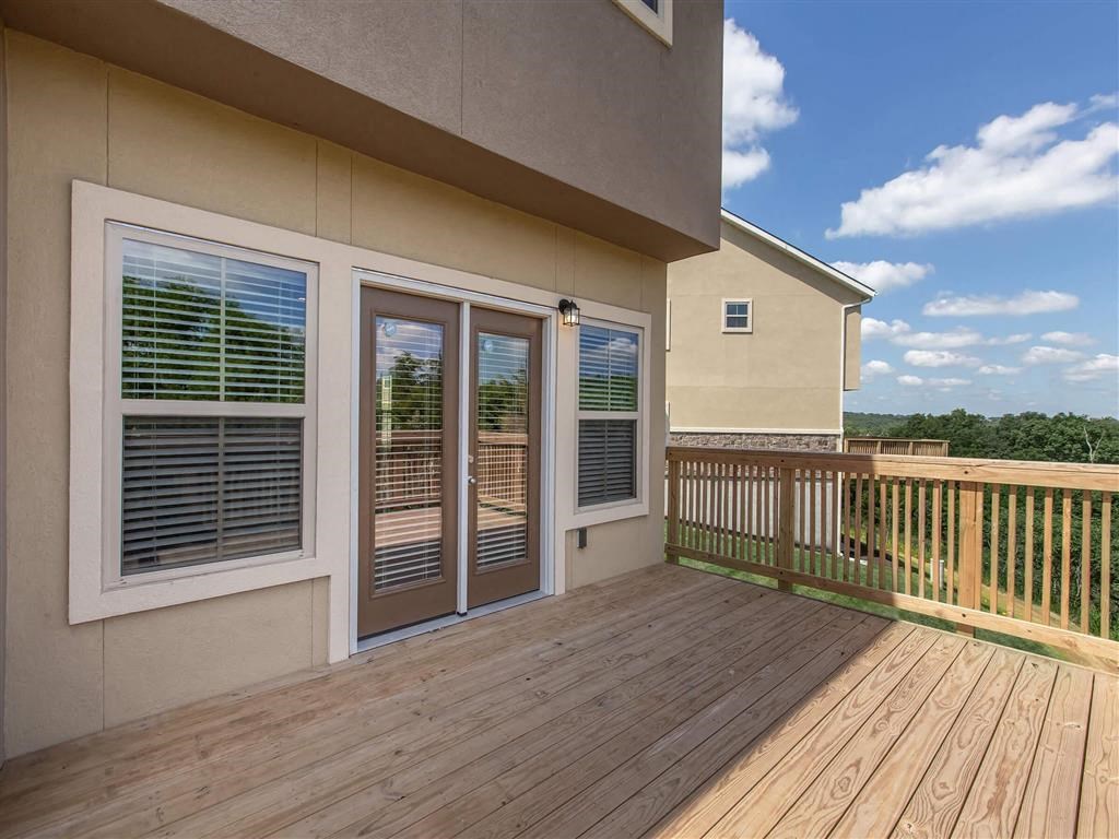 a deck with a house in the background