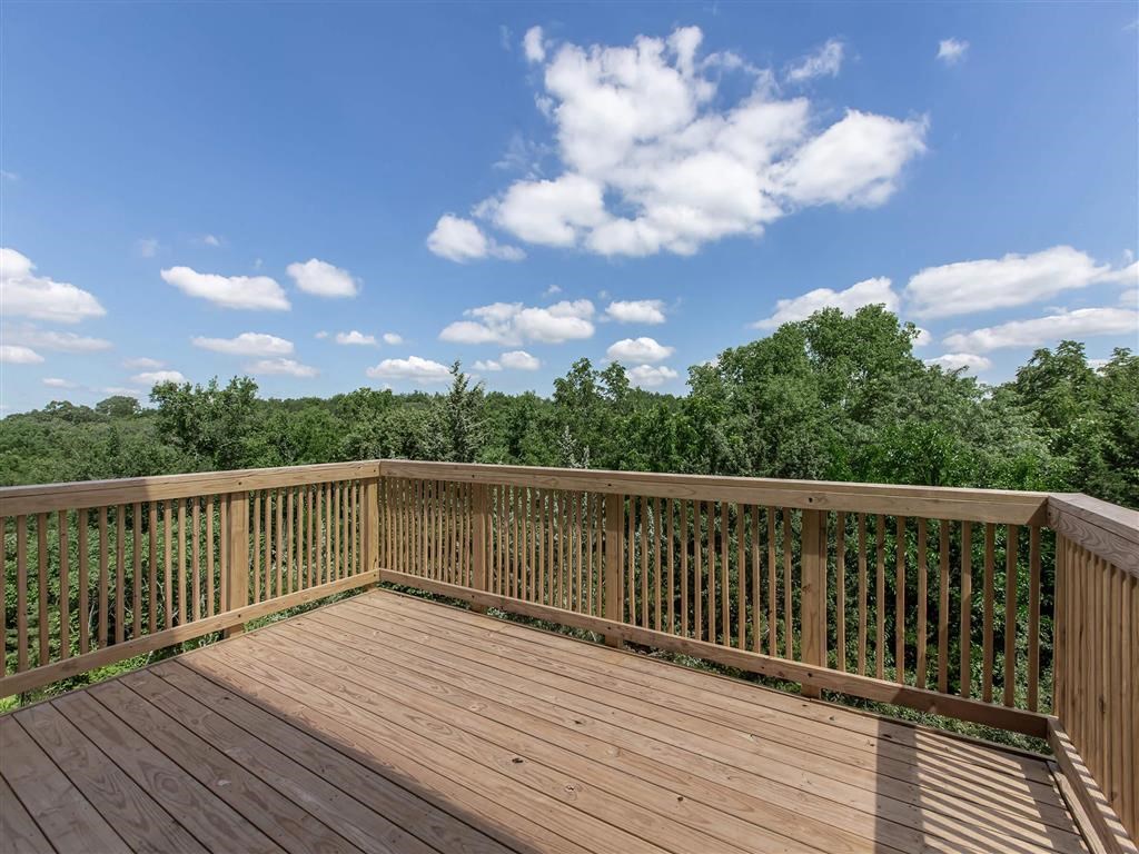 a balcony with a view of the woods