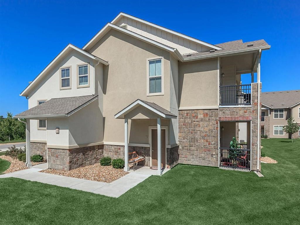 a beige house with a yard and grass