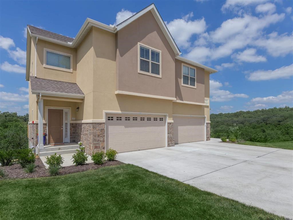 a beige house with a garage and a driveway