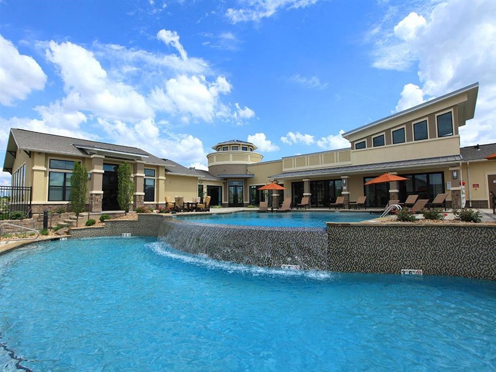 a large swimming pool with a building in the background