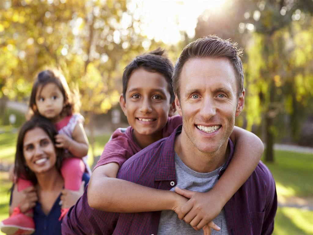 a family posing for a picture in the park