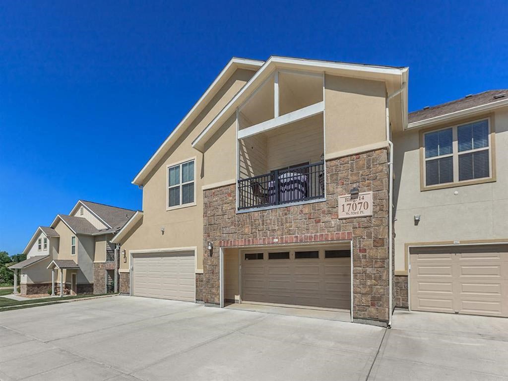 an empty driveway in front of a house with a garage door