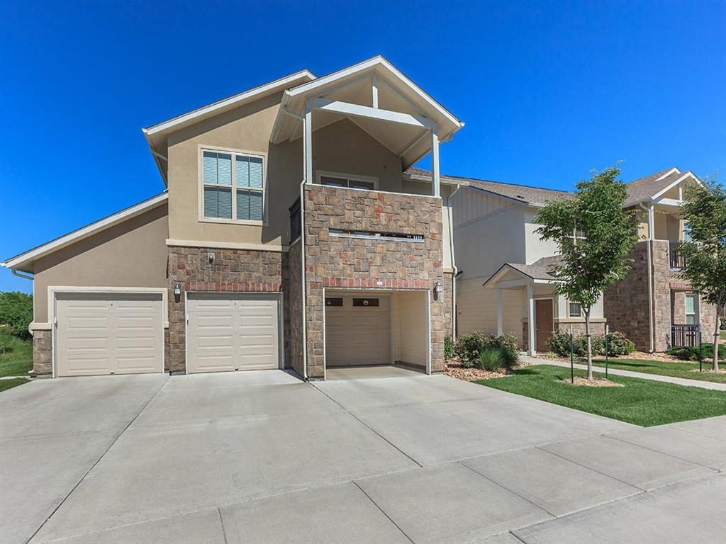 an empty driveway in front of a brick house