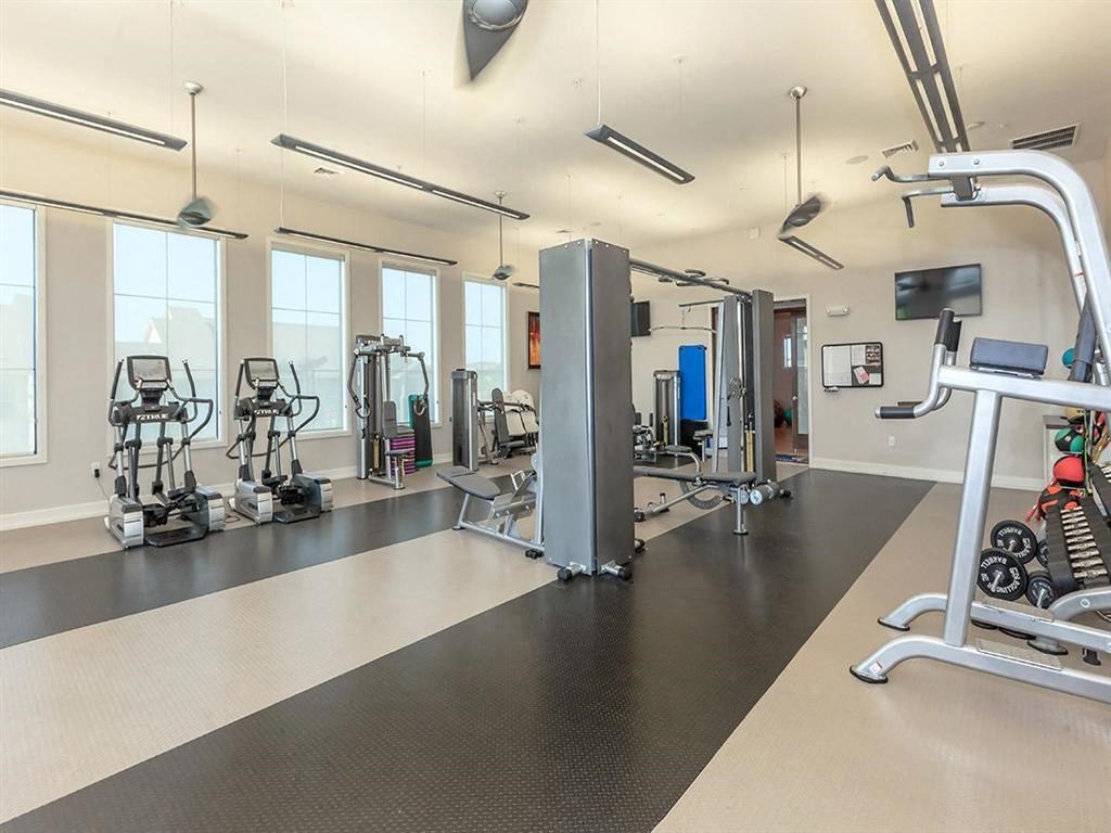 a gym with weights and cardio equipment in a building