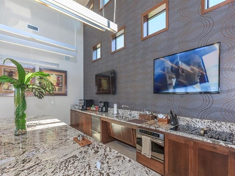 the kitchen has granite counter tops and a large tv