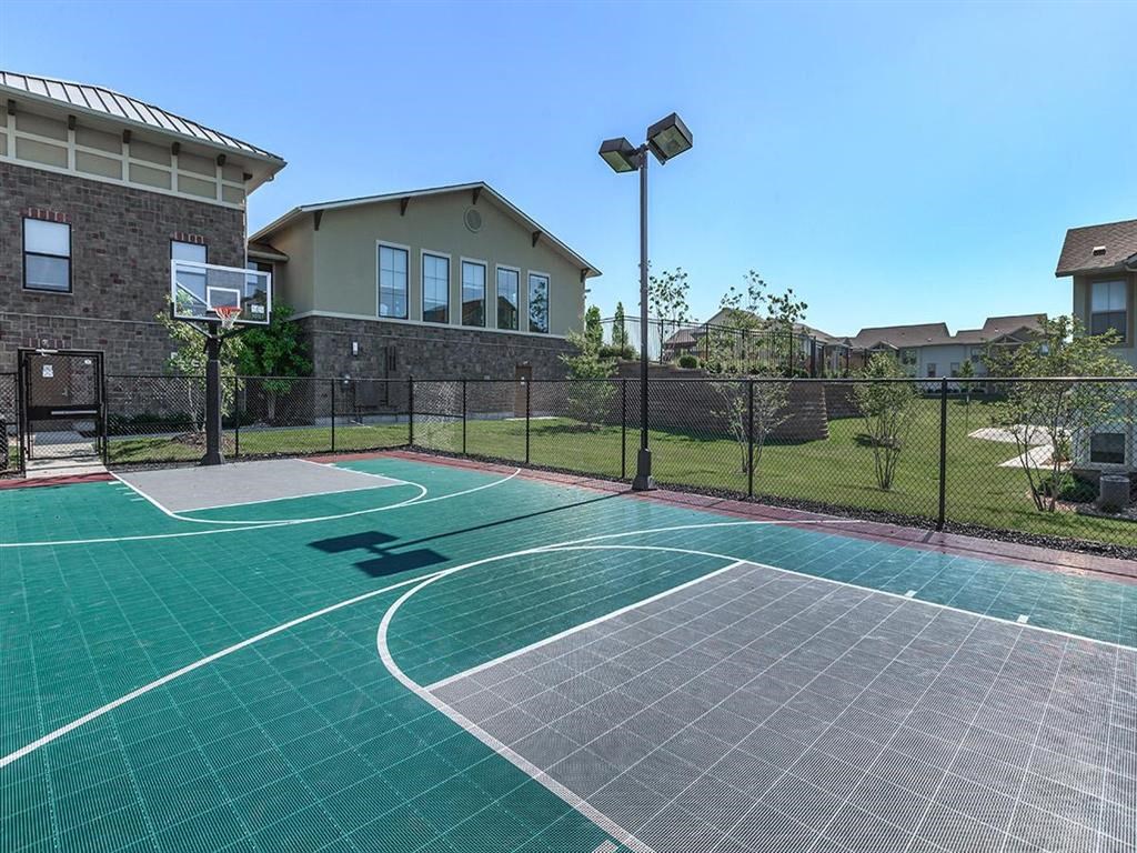 a basketball court with a house in the background
