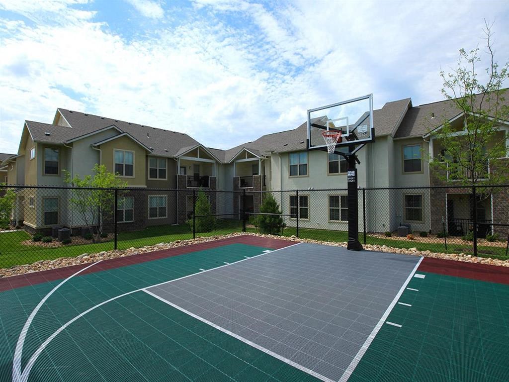 a basketball court in front of an apartment building