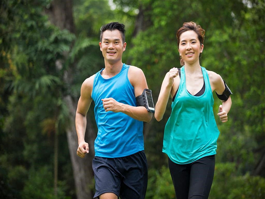 a man and a woman running through a forest