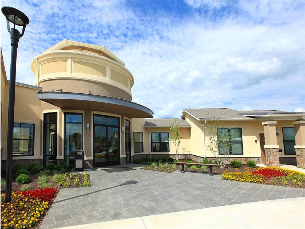 the front of a building with a patio and a clock tower