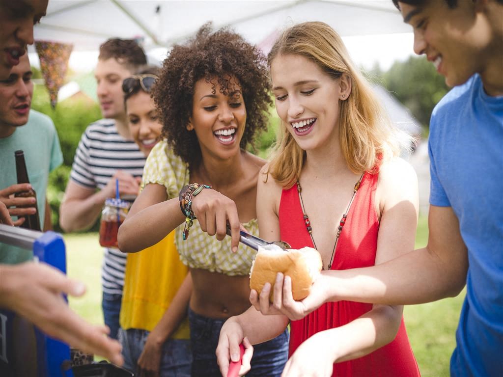 a group of people eating food at a picnic