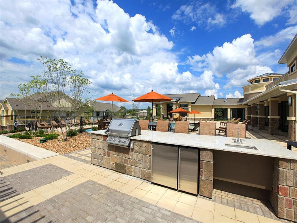 a large outdoor kitchen with a bar and umbrellas
