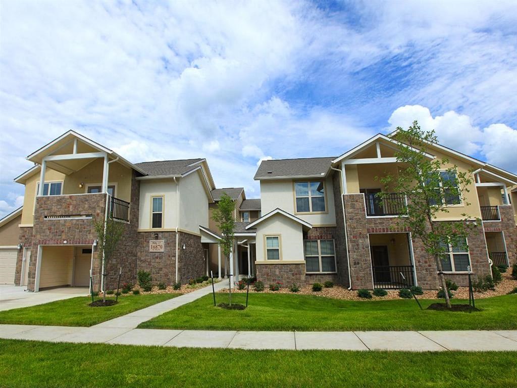 an exterior view of an apartment building with grass