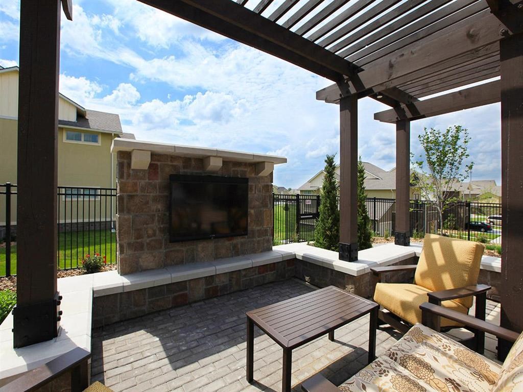 a patio with a fireplace and a table and chairs