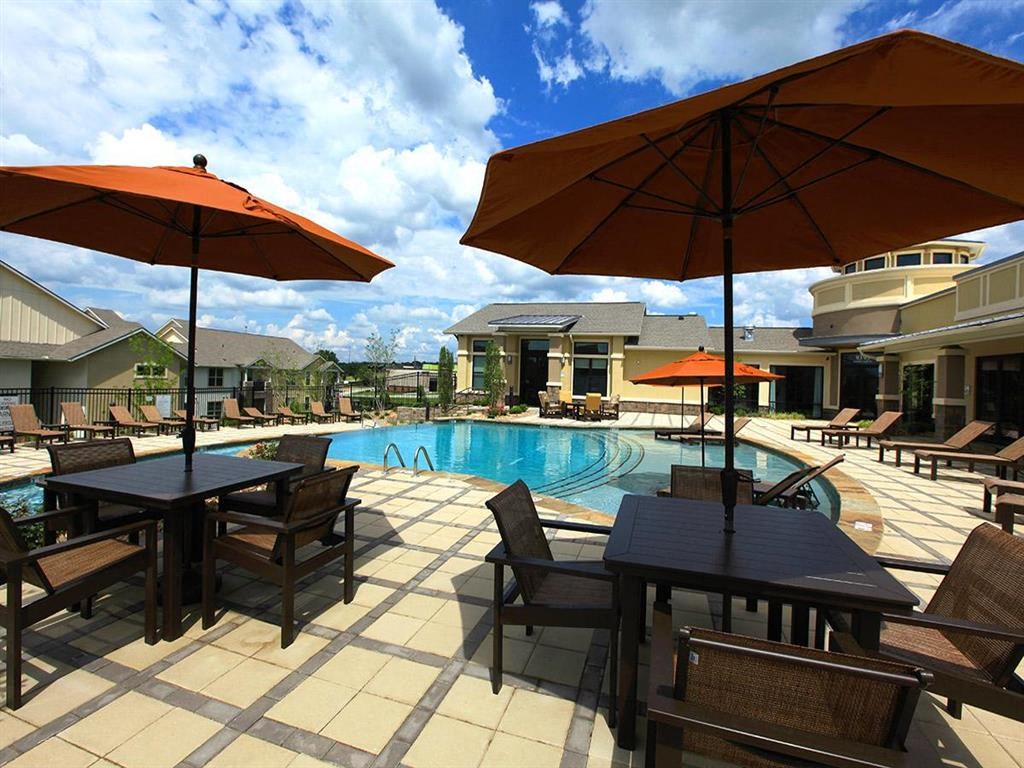 a swimming pool with tables and umbrellas