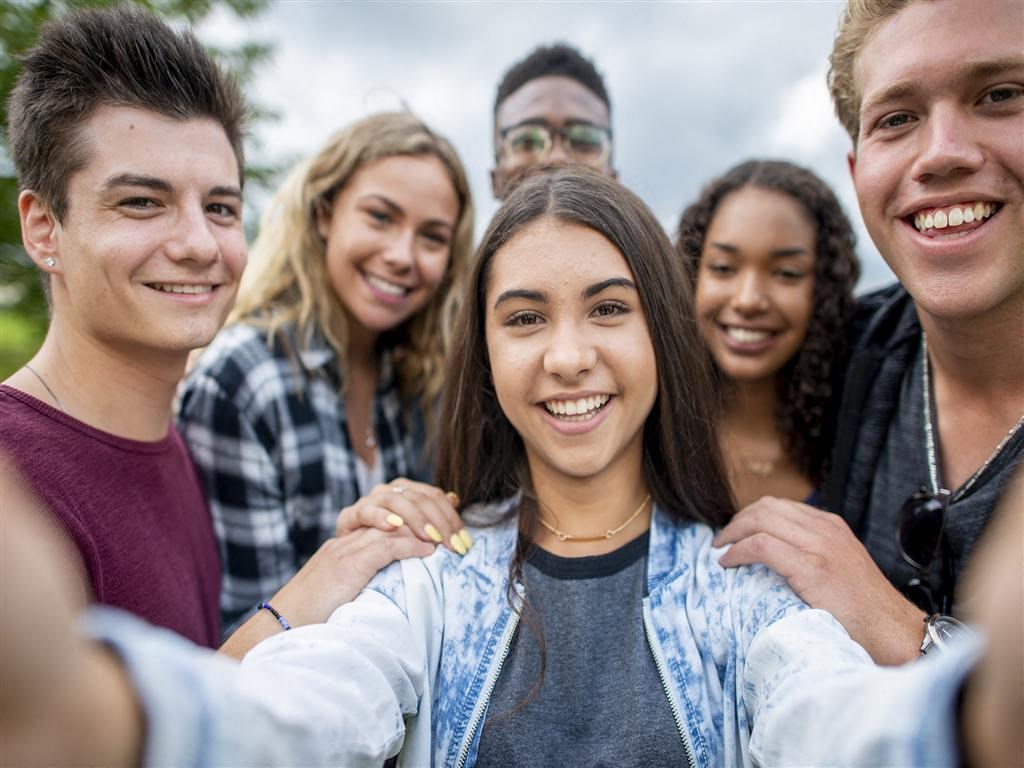 a group of young people smiling and posing for a picture