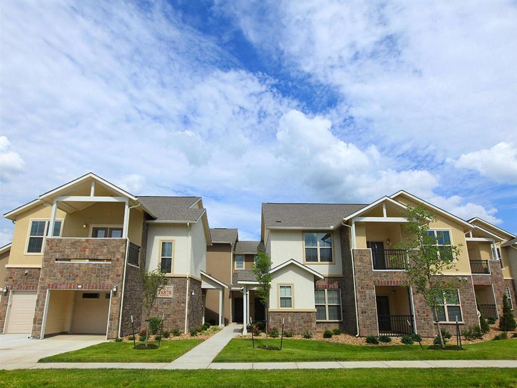 an apartment building with a sidewalk in front of it
