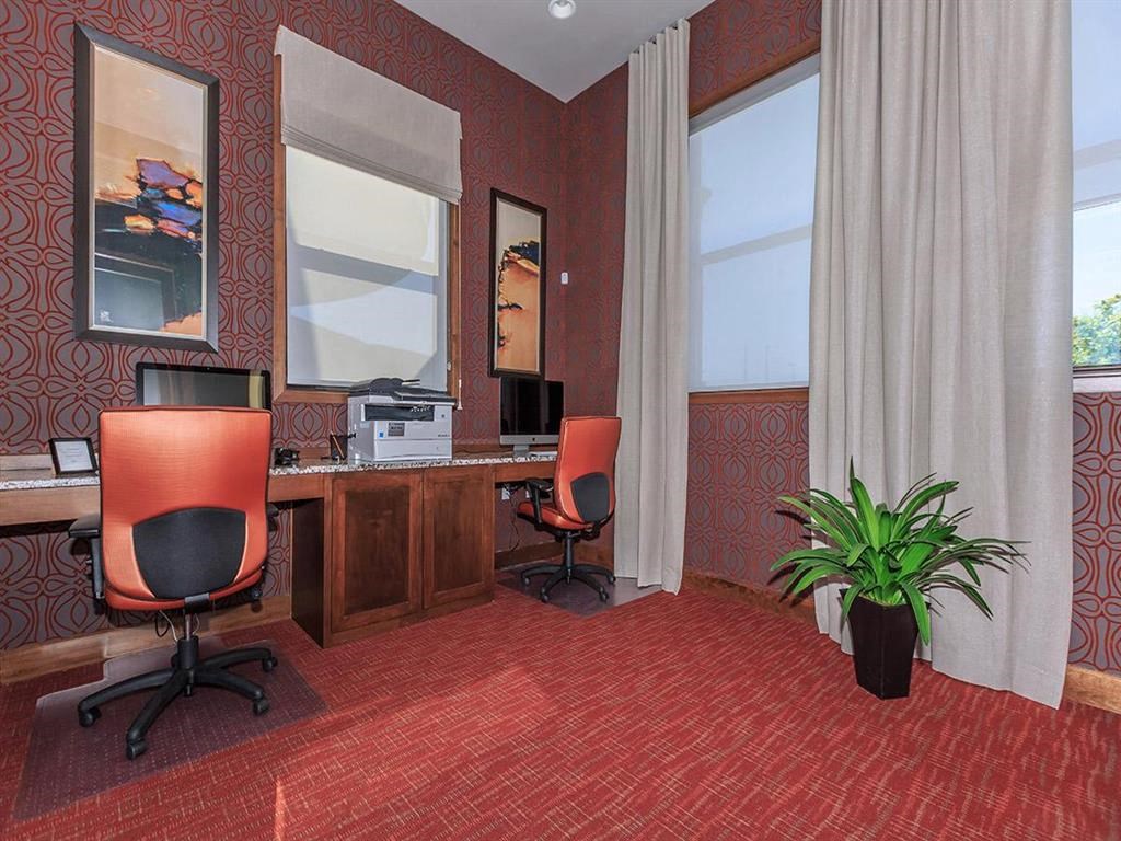 a conference room with two chairs and a desk with a computer