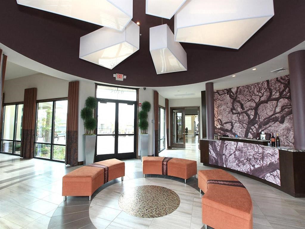 a lobby with orange couches and chairs and a mural on the wall