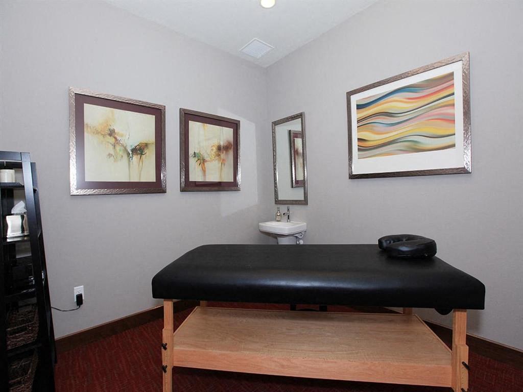 a room with a massage table and three paintings on the wall