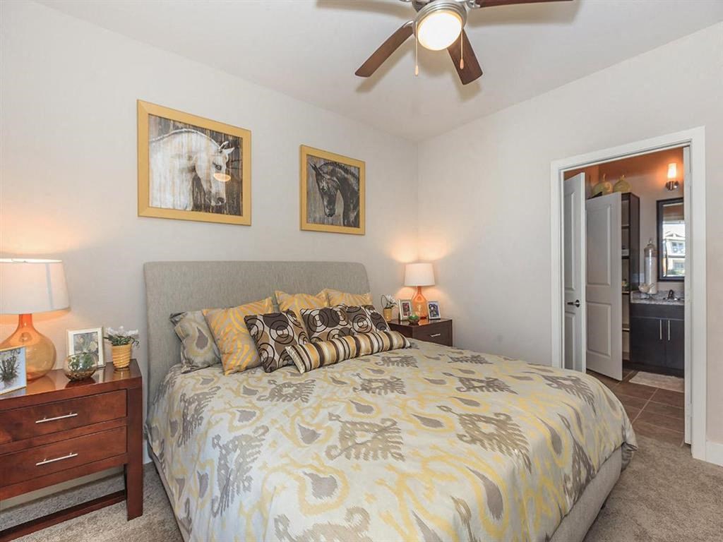 a bedroom with a bed and a ceiling fan