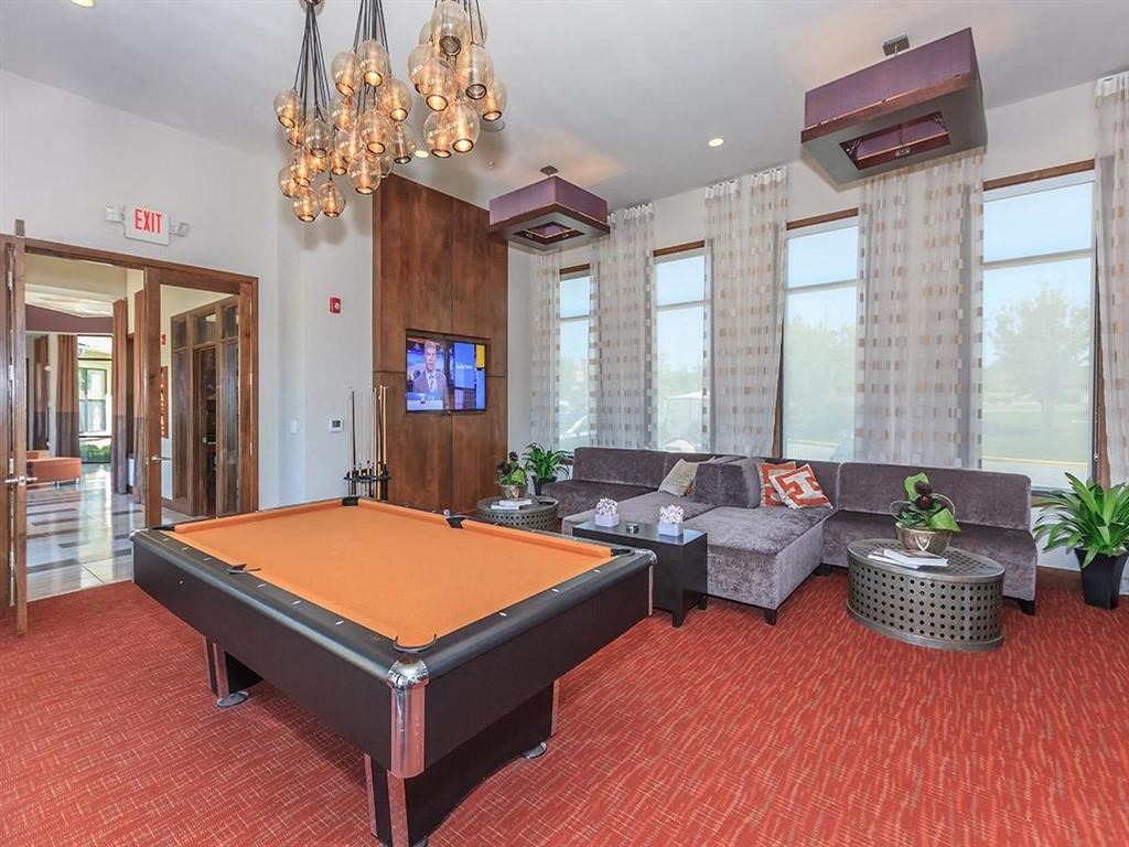 a game room with a pool table and a tv
