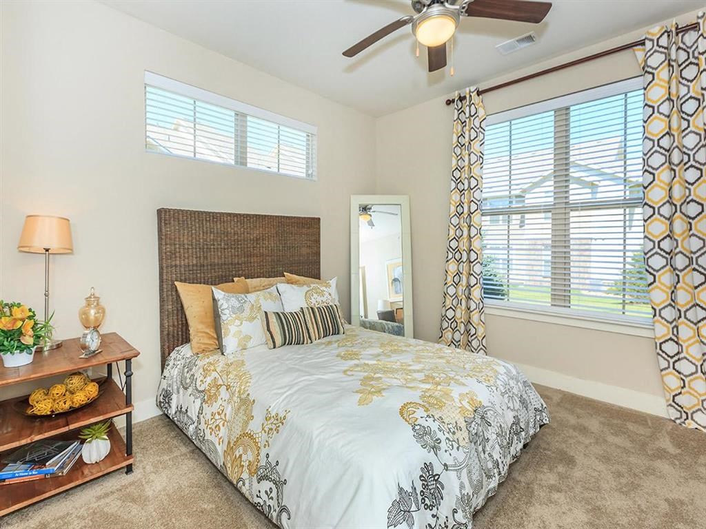a bedroom with a bed and a ceiling fan