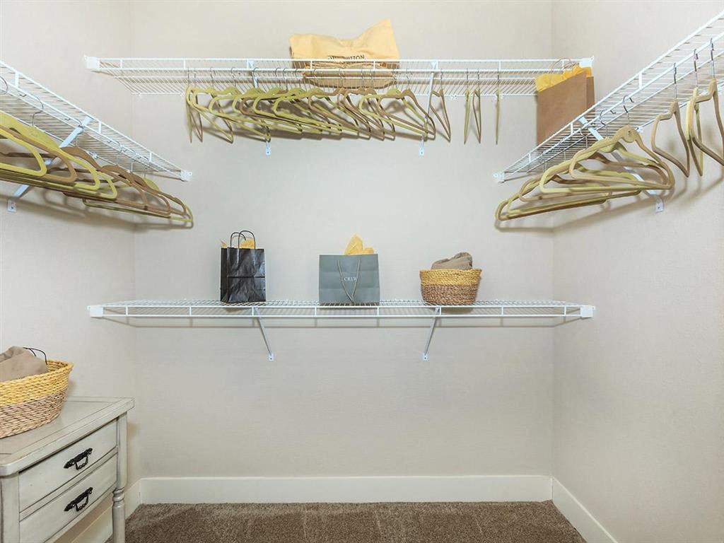 a closet with shelves and racks with bags and baskets