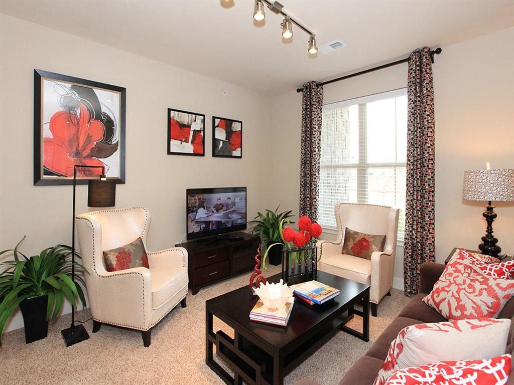a living room with a couch and chairs and a television