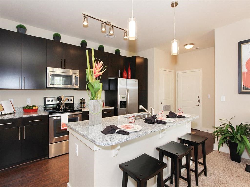 a kitchen with a bar and black cabinets