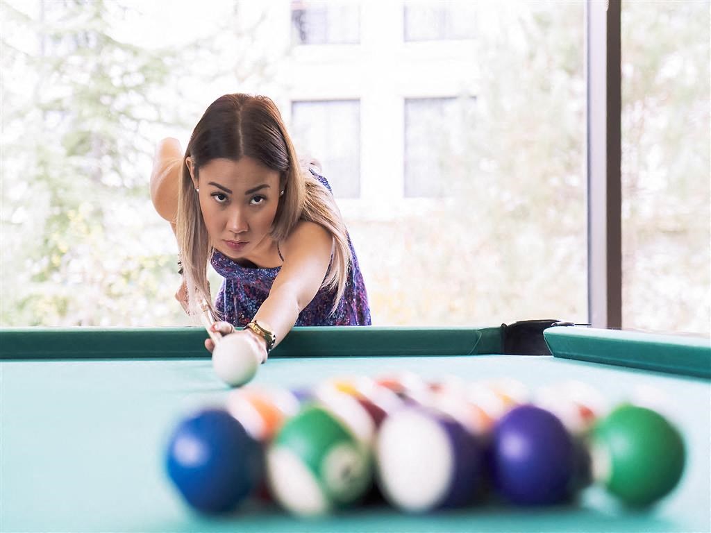 a woman playing a game of pool on a pool table