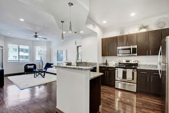 an open kitchen and living room with an island and stainless steel appliances