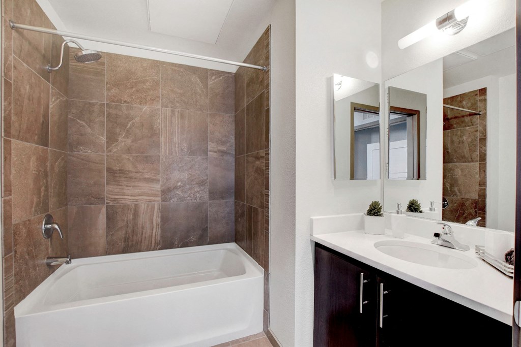 a bathroom with a tub and a sink and a mirror