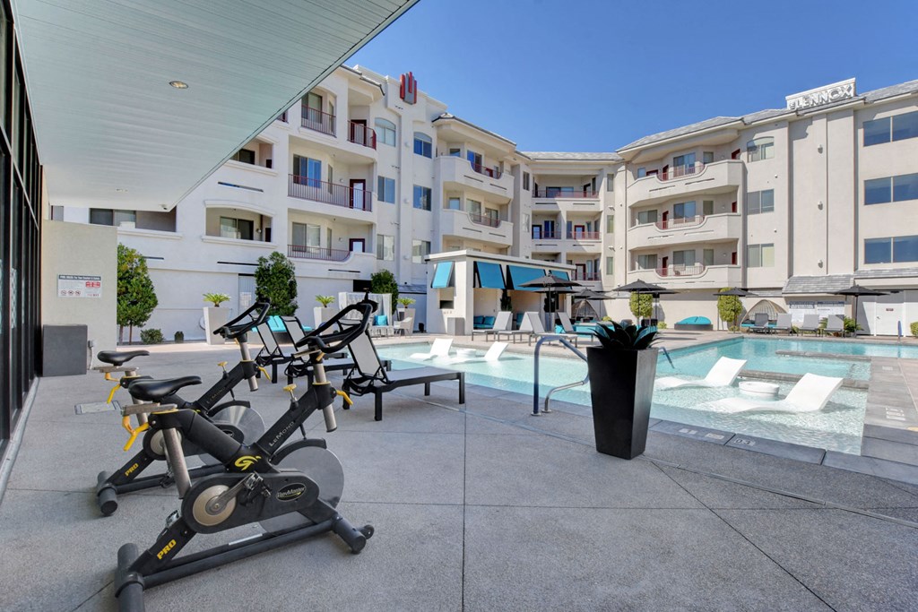 a group of exercise bikes in front of a pool at a hotel
