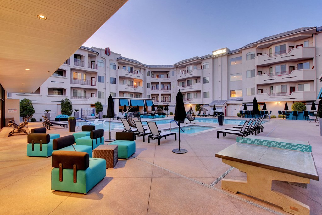 a view of the courtyard of a hotel with a pool and lounge chairs