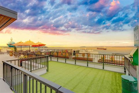 a view of the ocean from a rooftop patio with grass