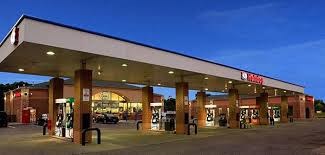 a gas station with people standing outside of it