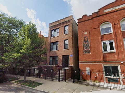 the facade of a brick building with a mural on the side