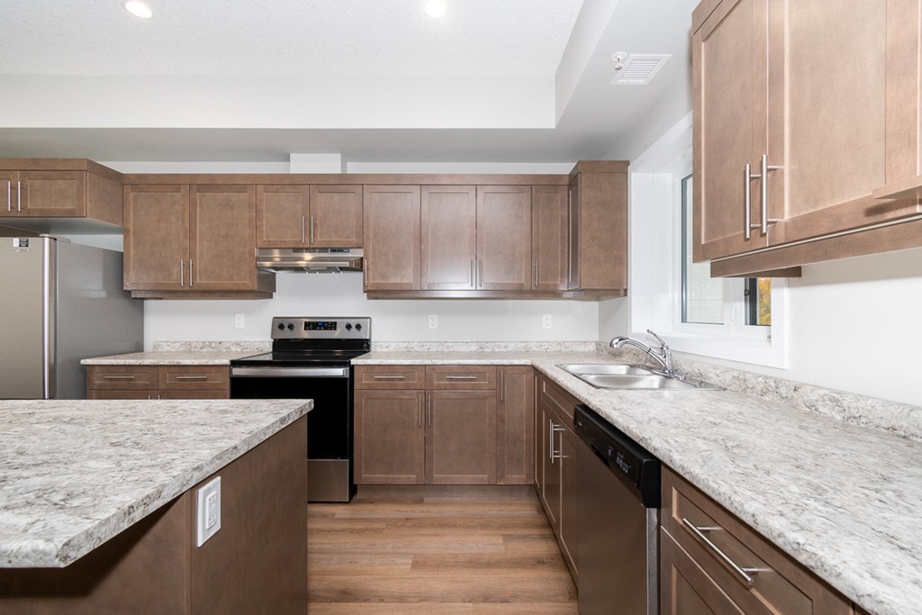 a kitchen with marble counter tops and wooden cabinets