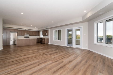 the living room and kitchen of a new home with wood flooring
