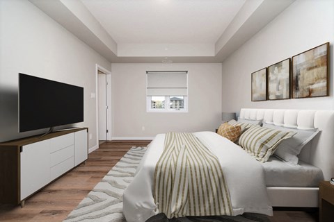 a white bedroom with a bed and a television